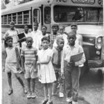 African-American children in front of school bus, 1965